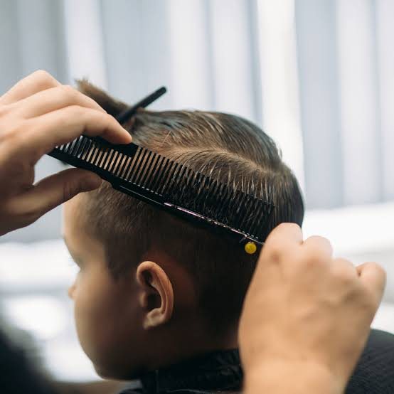 Close up of a comb and clipper being used for a child's haircut